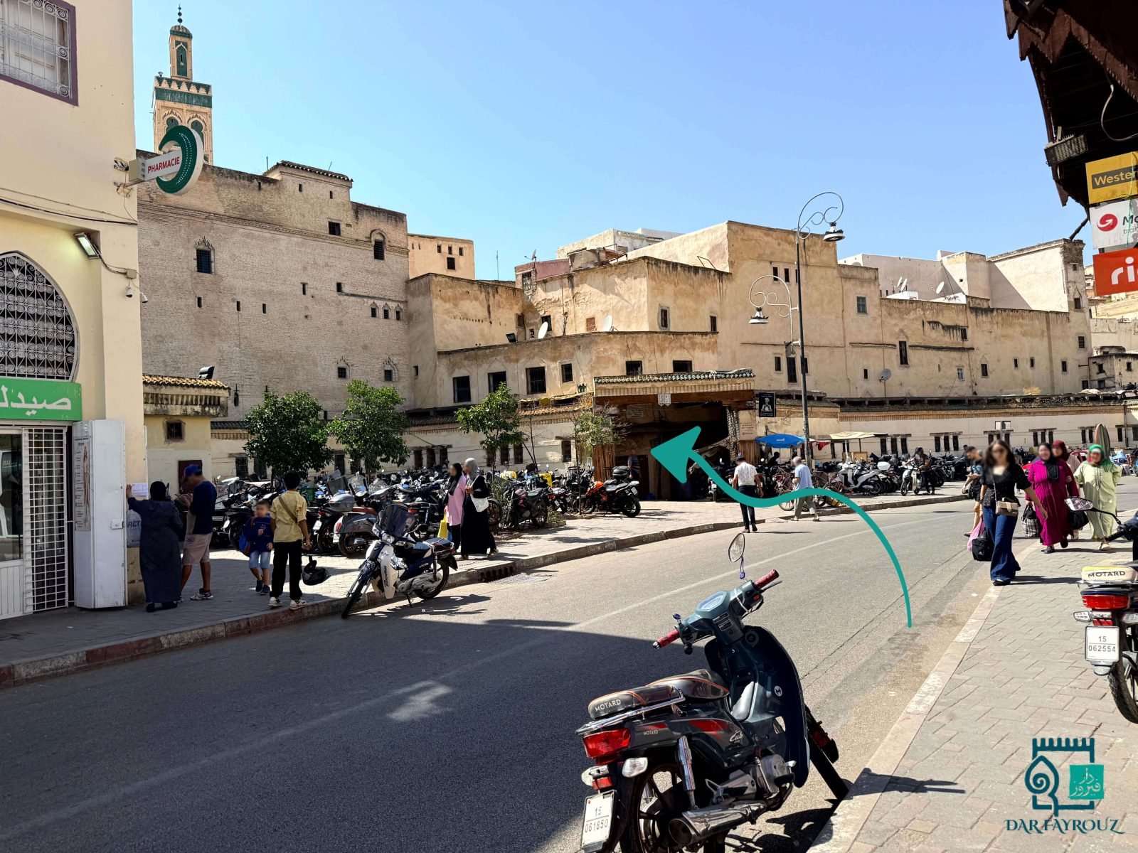 View from the inwi corner: the covered gateway across the road, a minaret on the left