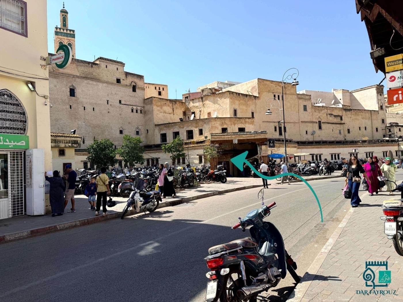 View from the inwi corner: the covered gateway across the road, a minaret on the left
