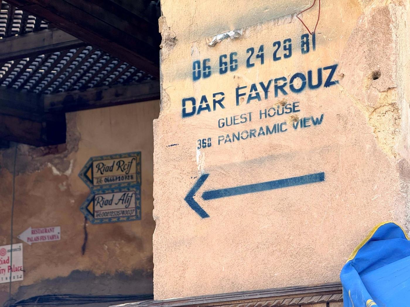 Dar Fayrouz stencil on the gateway pillar, arrow pointing into the passage