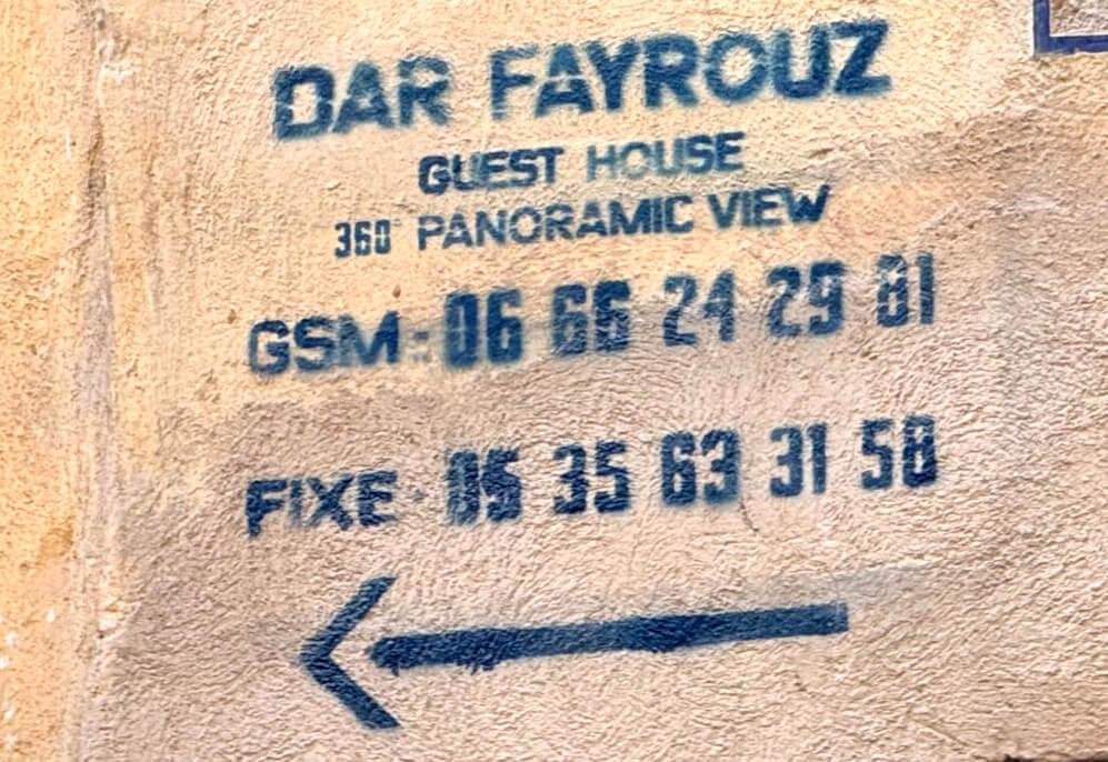 Dar Fayrouz stencil at the end of the narrow lane, arrow pointing left