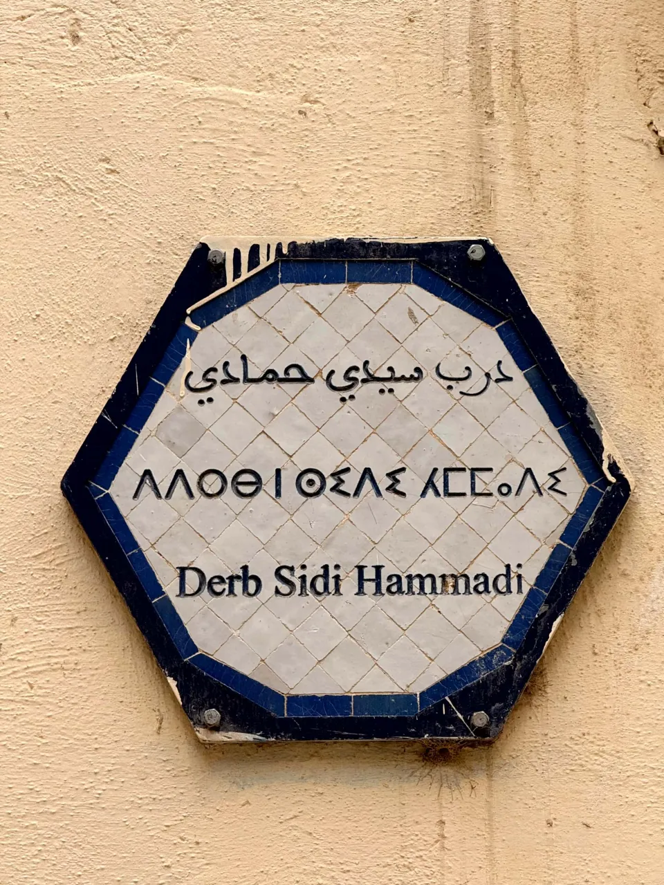 Hexagonal plaque of Derb Sidi Hammadi in Arabic, Tamazight in Tifinagh letters, and French